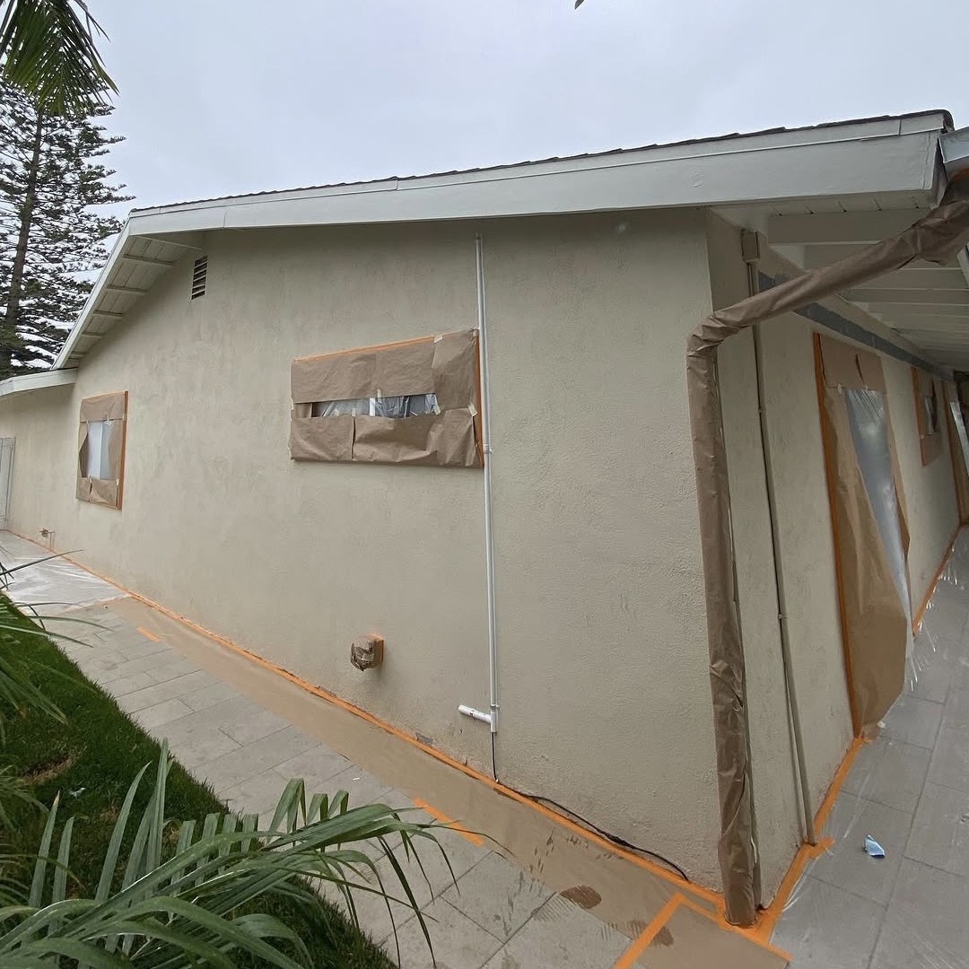 Before: the same wall masked in brown paper and orange tape, ready to paint